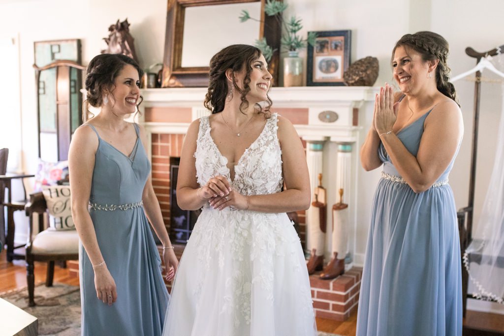 Two Maids of Honor helping the bride get dressed