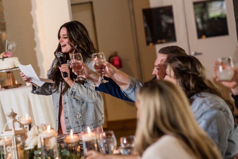 A Maid of Honor giving her speech to the happy couple. This is the ending toast where everybody raises their glasses. This photo shows the Maid of Honor raising her glass with a few other wedding guests