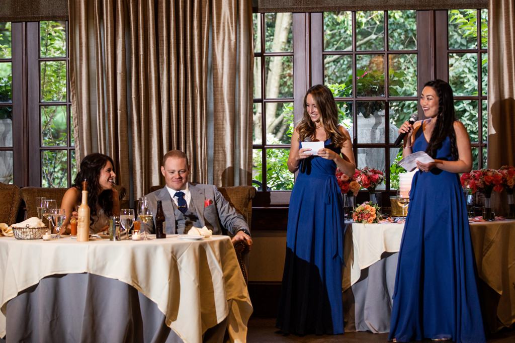 A bride and groom smiling as 2 Maids of Honor give wedding speeches. This is for the articles called can you have two maids of honor