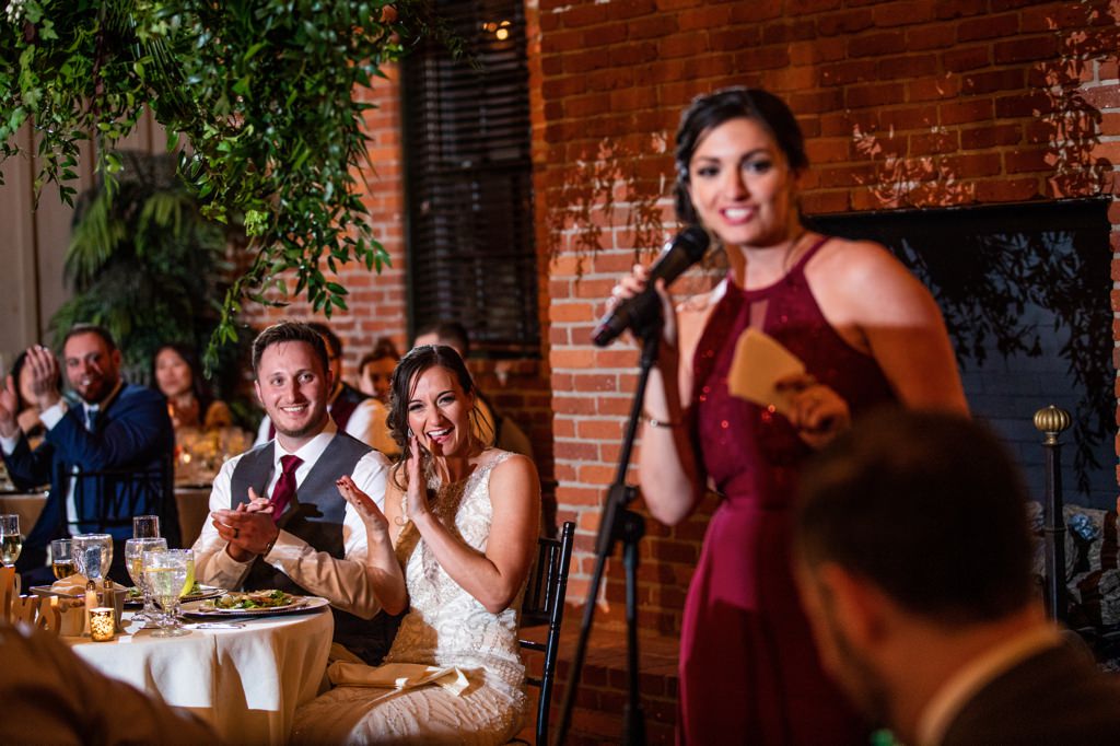 A couple laughing as the Maid of Honor gives a speech. This is for the article called Disney quotes for Maid of Honor speech.