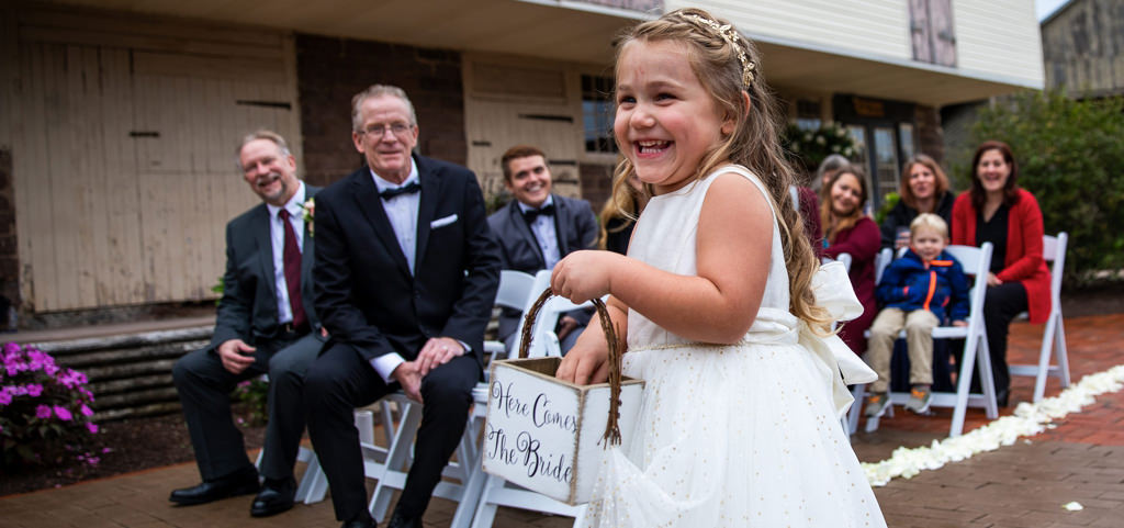 A flower smiling as she walks down the aisle. This is for the article called best flower girl entrance songs.
