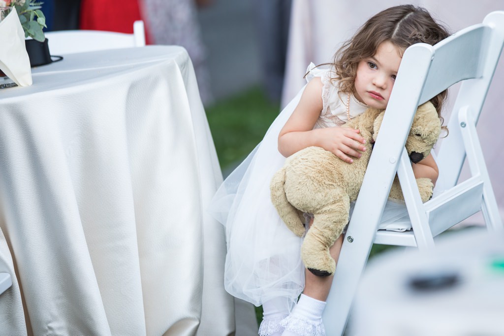A flower girl looking bored at a wedding reception. This is for the article called how do you entertain children at a wedding