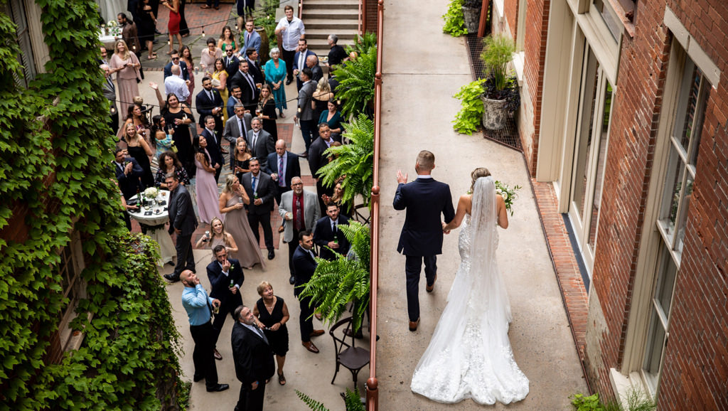 The bride and groom walking into cocktail hour at a wedding