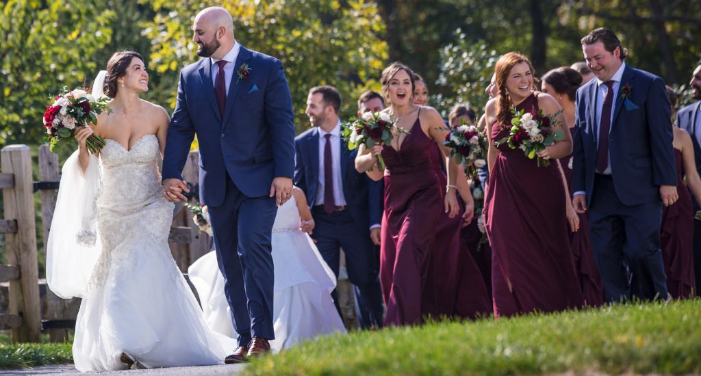 A bride and groom walking with the wedding party.
