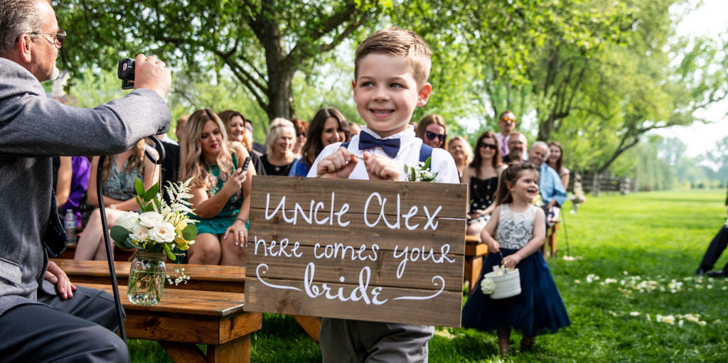 A cute ring bearer walking down the aisle at a wedding ceremony. This is for the article called best ring bearer entrance songs