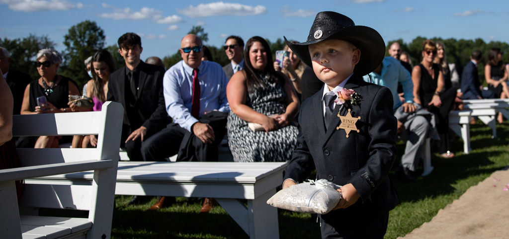 A ring bearer walking down the aisle with the wedding rings
