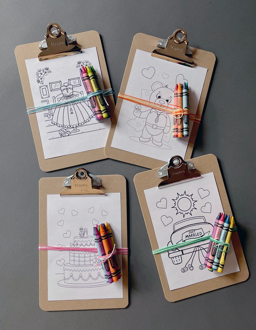 A photo that shows four printable wedding-themed coloring sheets for kids. Each has a small bundle of crayons attached to it. This is for the article called wedding coloring pages for kids