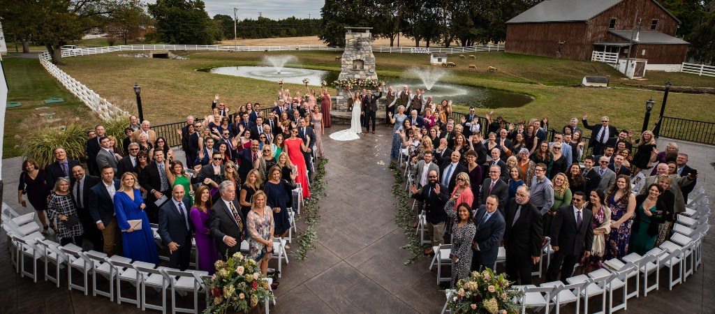 A bride and groom posing with all of their wedding guests