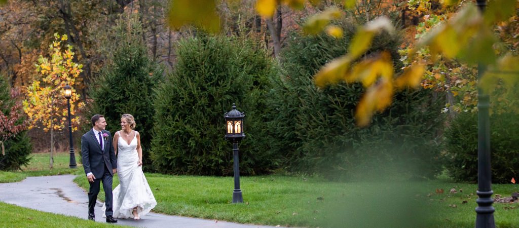 A bride and groom walking down a path after a fall wedding. This is for the article called the best month to get married