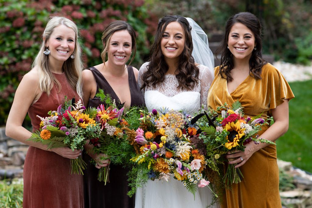 A bride and bridesmaids holding their wildflower bouquets.