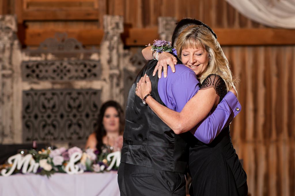 A mom hugging her son after the mother-son dance. This is for the article called mother-son wedding dance tradition