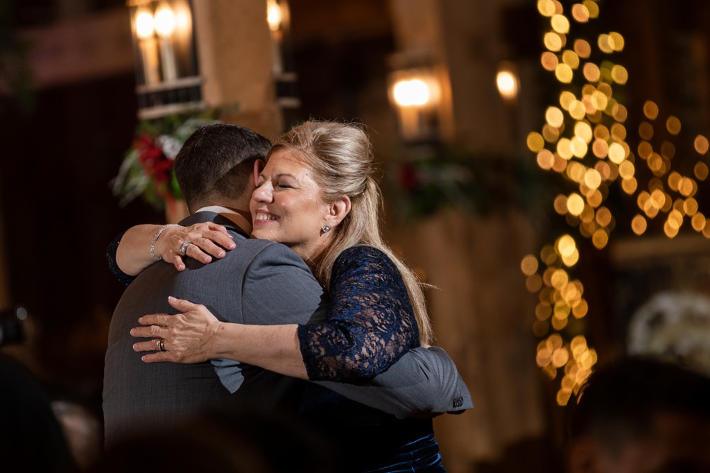 A proud mom hugging her son after the mother-son dance at a wedding
