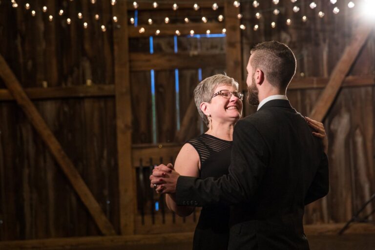 A proud mom smiling at her son during the mother-son wedding dance