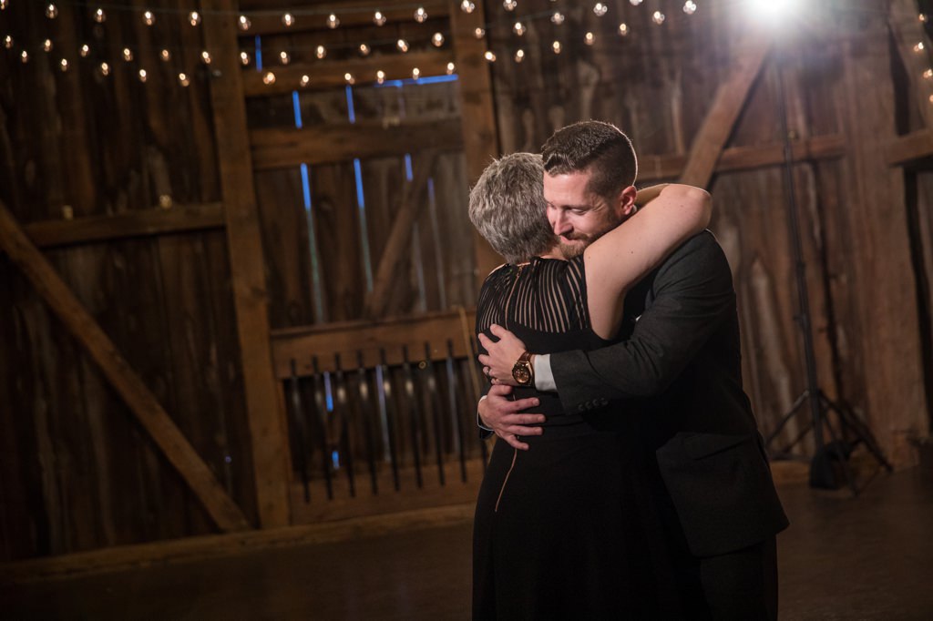 A groom hugging his mom after the mother-son wedding dance
