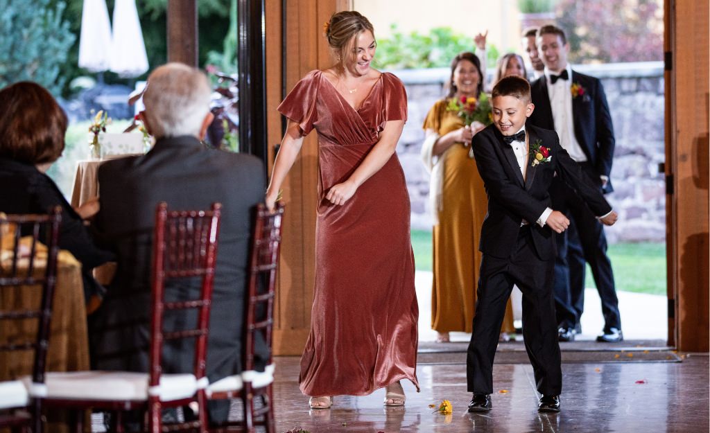 A bridesmaid and ring bearer having fun during the wedding party introductions