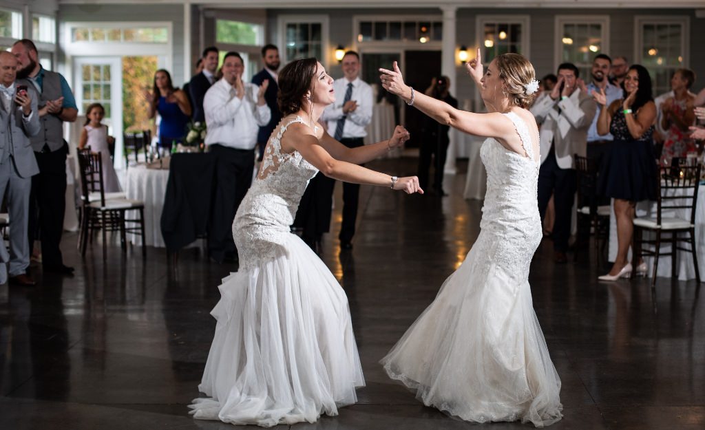 Two brides having fun during their wedding reception grand entrance