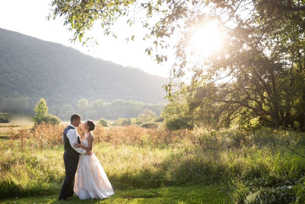 A bride and groom posing in a field