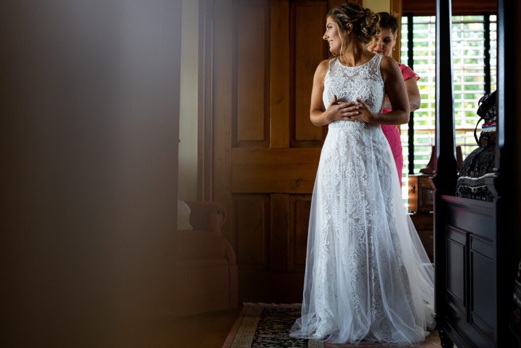A bride getting her dress as she looks out the window