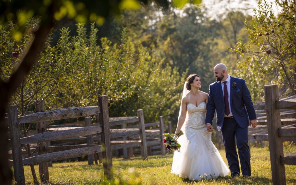 A bride and groom walking in a field. This is for the blog post called how to plan a wedding for $10,000 or less