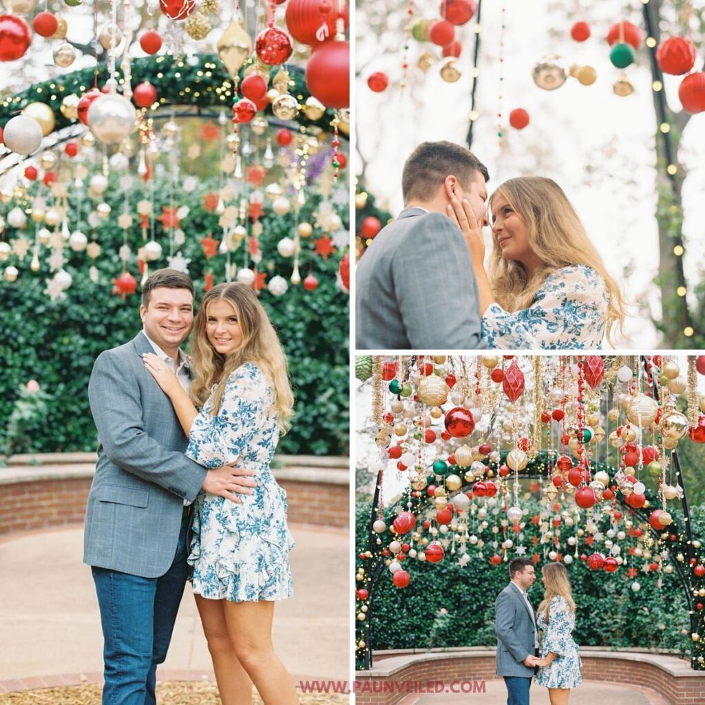 A couple posing for engagement photos outside near a bunch of Christmas decorations