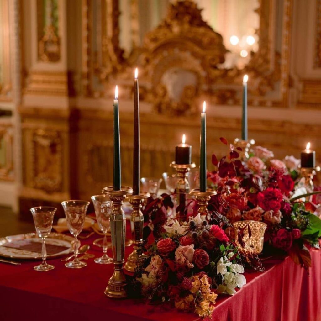 gold and red christmas wedding centerpieces on a table with candles