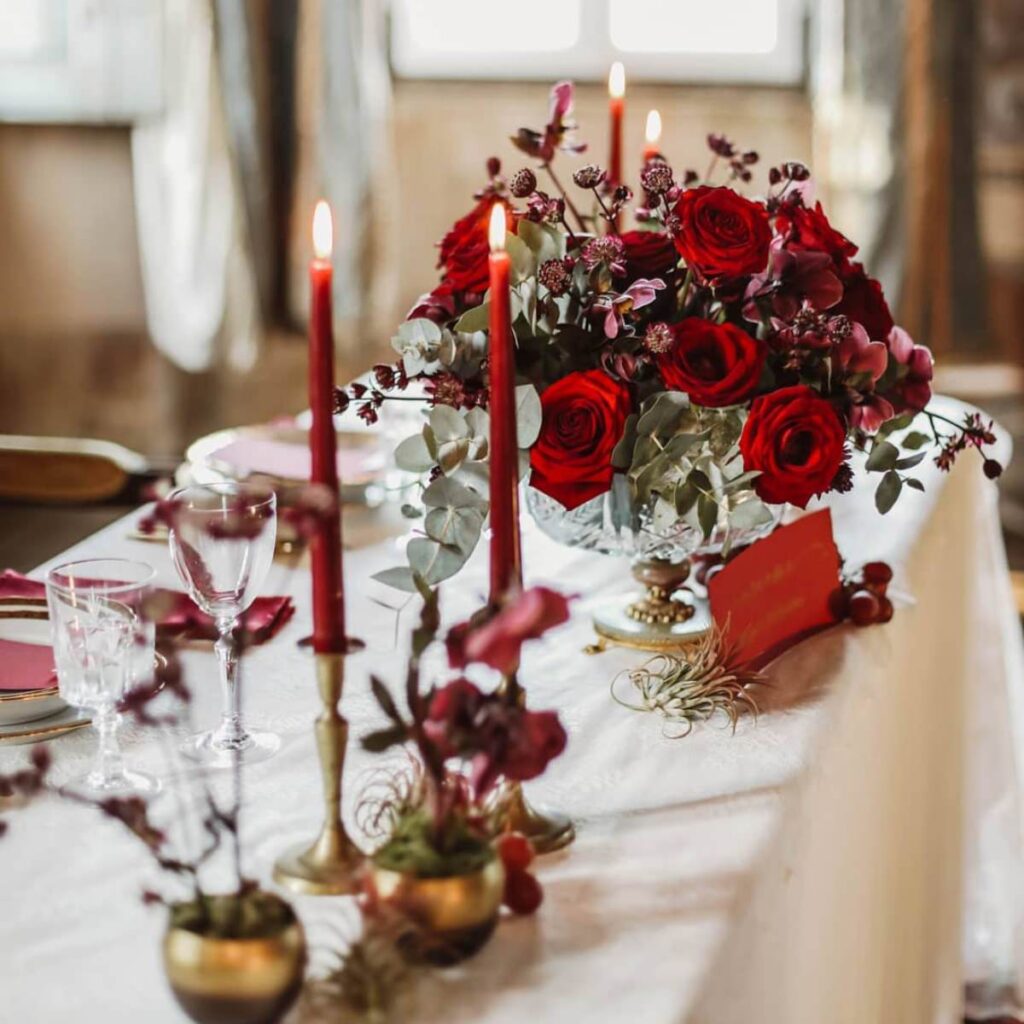 Red candles and Xmas-inspired wedding centerpieces