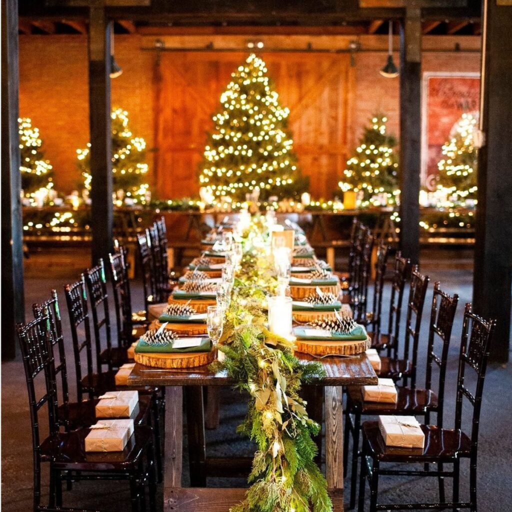 A long wedding reception table with Christmas trees in the background