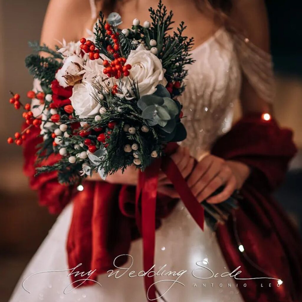 A beautiful Christmas wedding bouquet with white, green, and red tones.