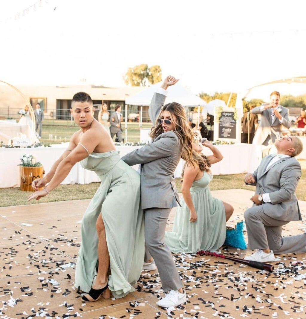 A funny wedding party entrance ideas that shows a bridesmaids in a groomsmen suit and a groomsmen in a bridesmaid dress.