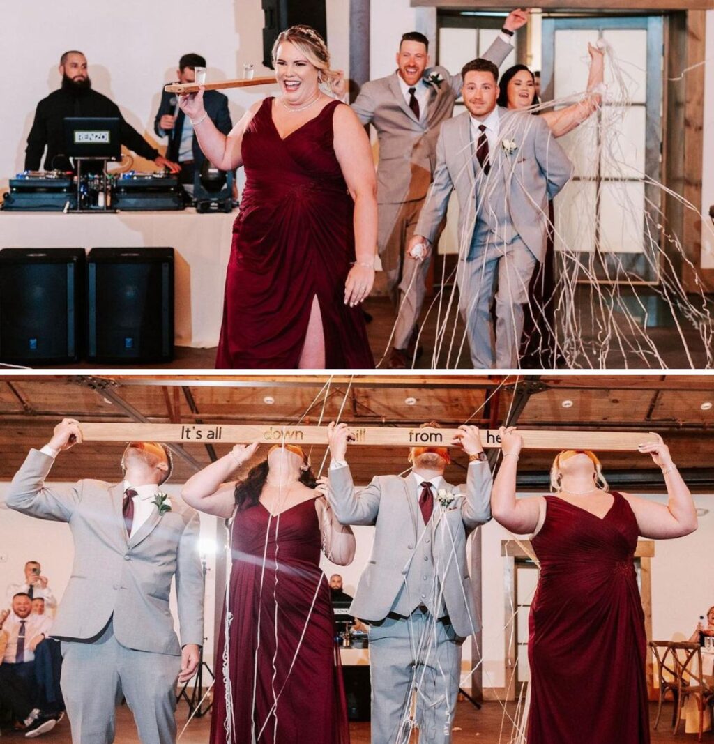 The wedding party entering the reception and taking a group shot from a long wood board.