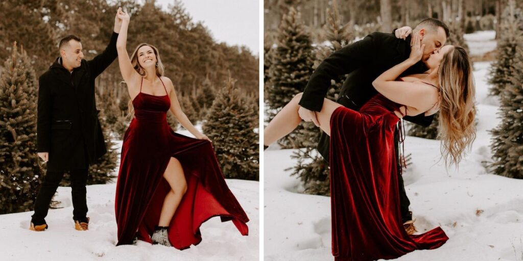 A couple in a suit and red dress posing for engagement pictures in the snow
