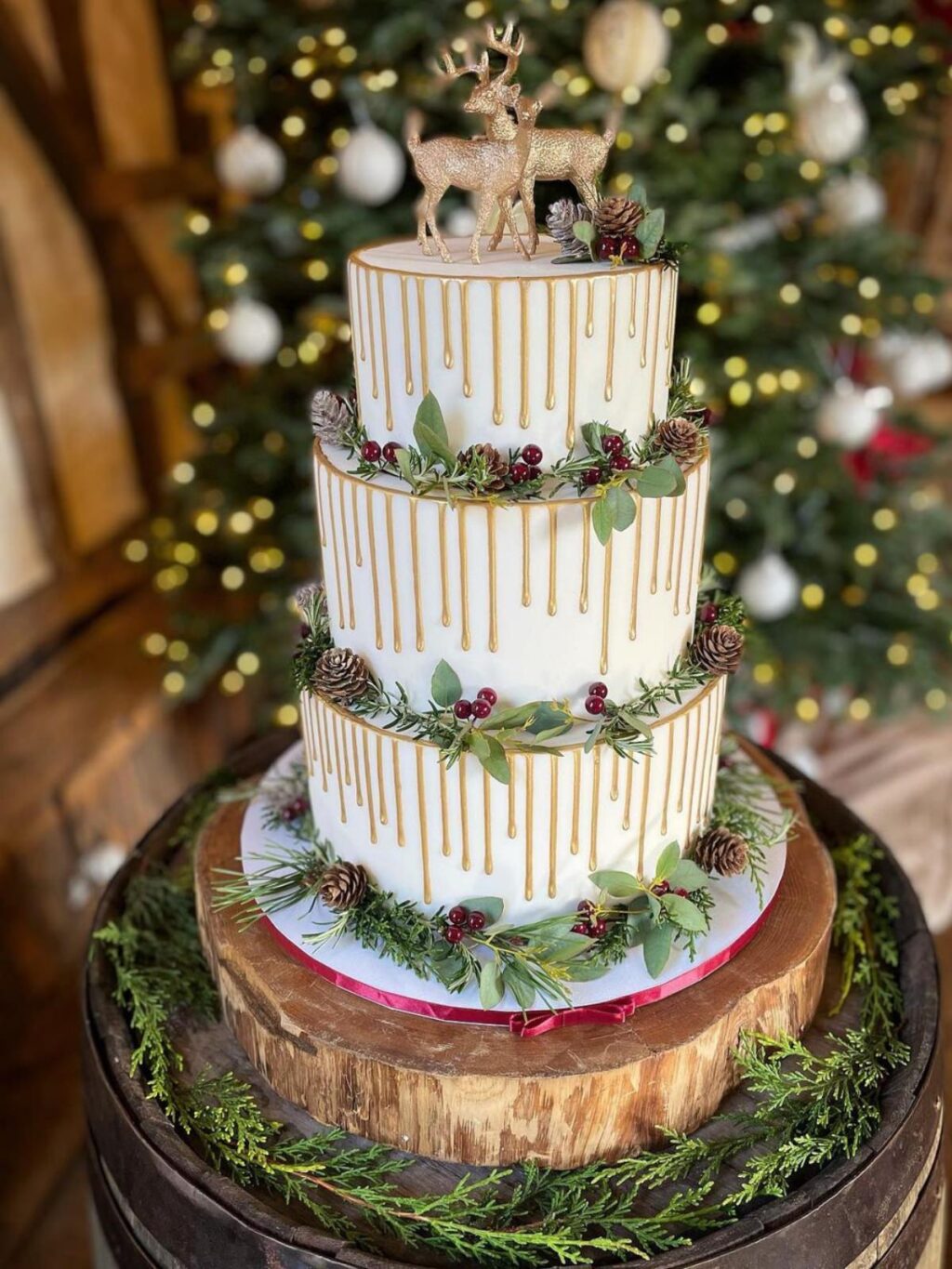 A gorgeous wedding cake with 3 tiers, gold drizzle and deer cake topper