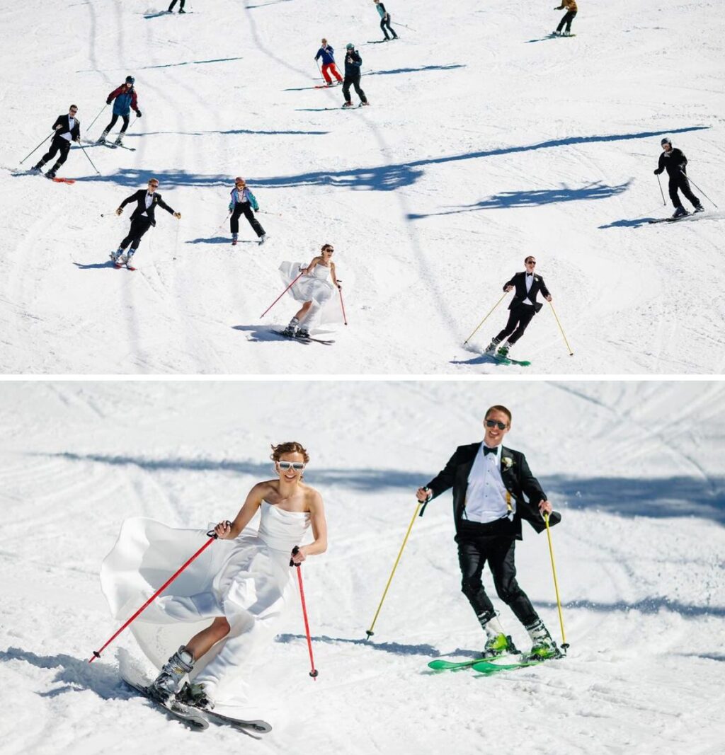 A bride and groom and their wedding party skiing down a hill on a snow filled mountain in the winter. They are all wearing their wedding attire