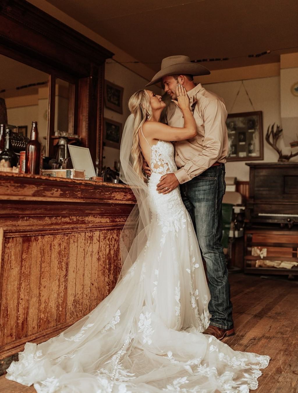 A bride and groom kissing in a western style bar or room.