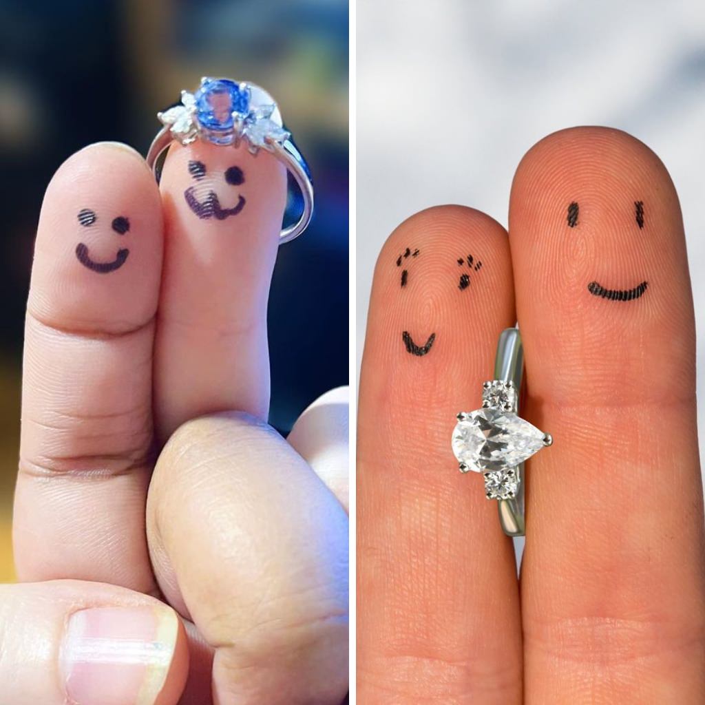Close up of fingers holding an engagement ring with little faces drawn on the fingers to look like a bride and groom