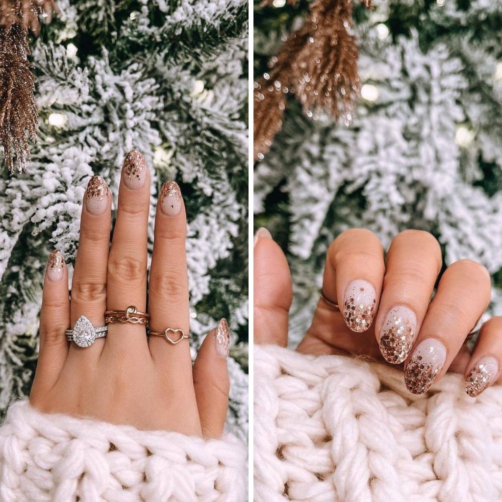 A close up of a woman's hand with Christmas holiday nails showing off her engagement ring with a Christmas tree in the background