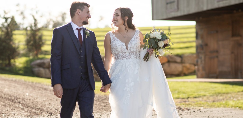 A bride and groom walking down a dirt road. This is for the article called how to make a wedding budget for beginners