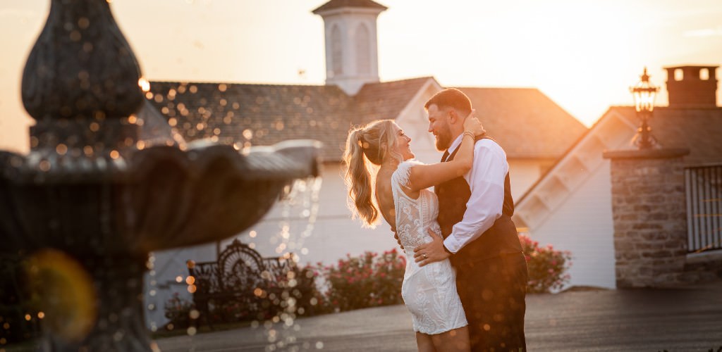 A bride and groom posing outside in the sunset light