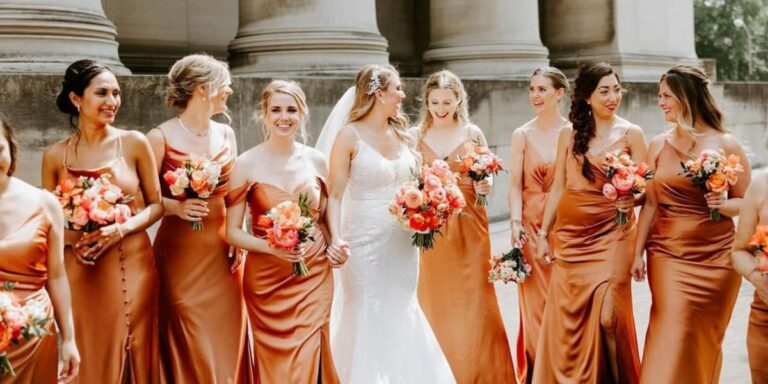 A bride and bridesmaids wearing orange bridesmaid dresses. This is the cover photo for the blog post called orange wedding colors