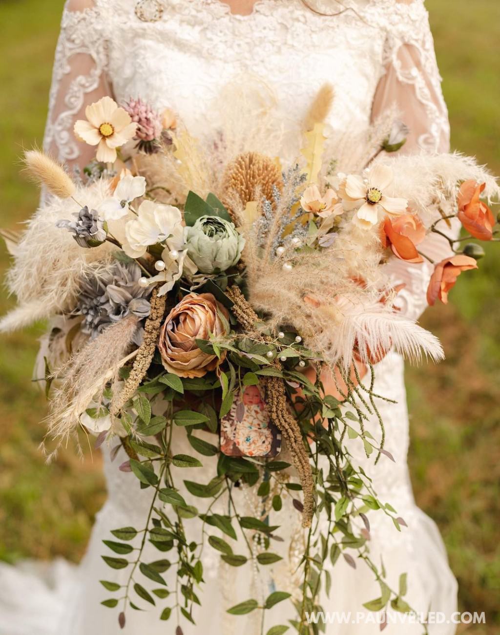 A large rustic wedding bouquet with a variety of flowers and textures.