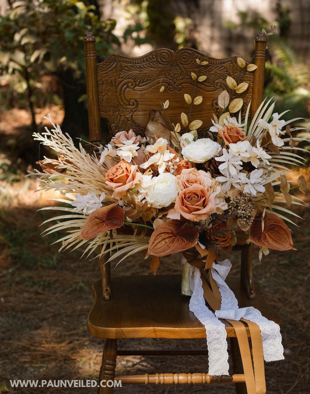 A stunning rustic bridal bouquet sitting outside on a brown chair