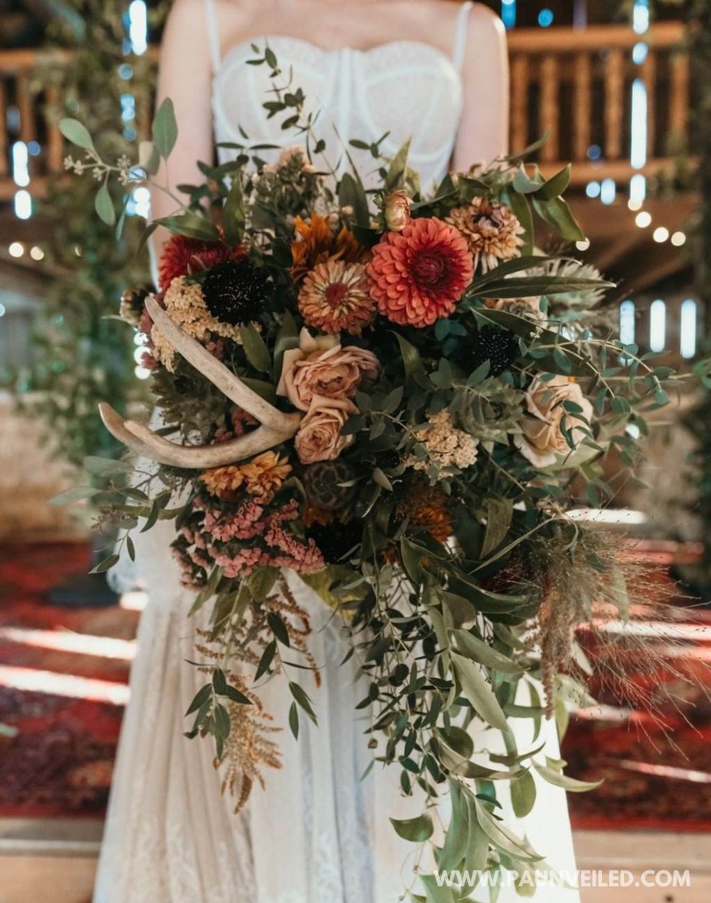 A big bridal bouquet with flowers and deer antlers. A very rustic look for flowers