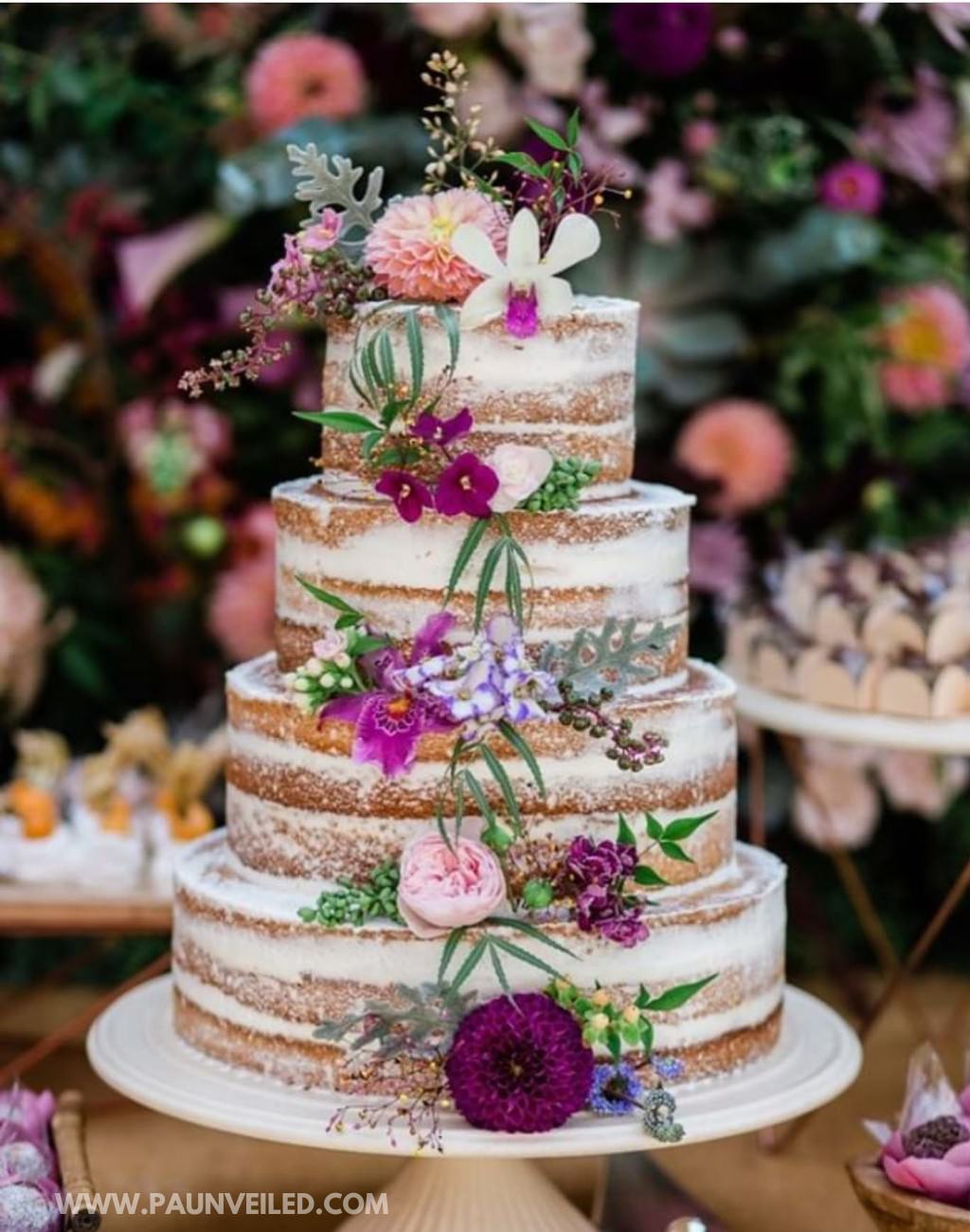A 4-tier semi-naked wedding cake with pink and purple flowers