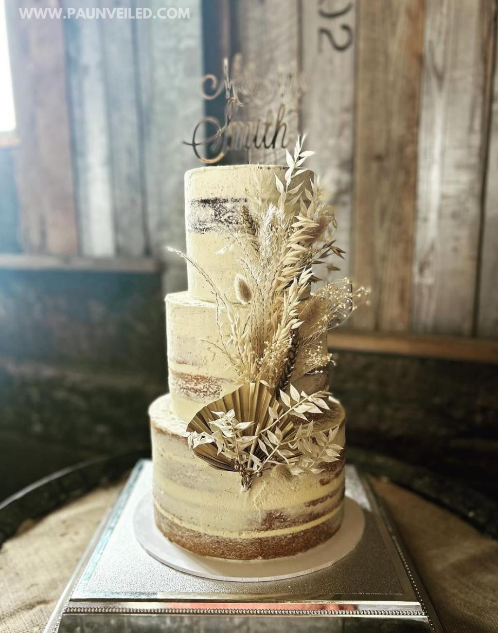 A 3-tier rustic boho style wedding cake with dried flowers