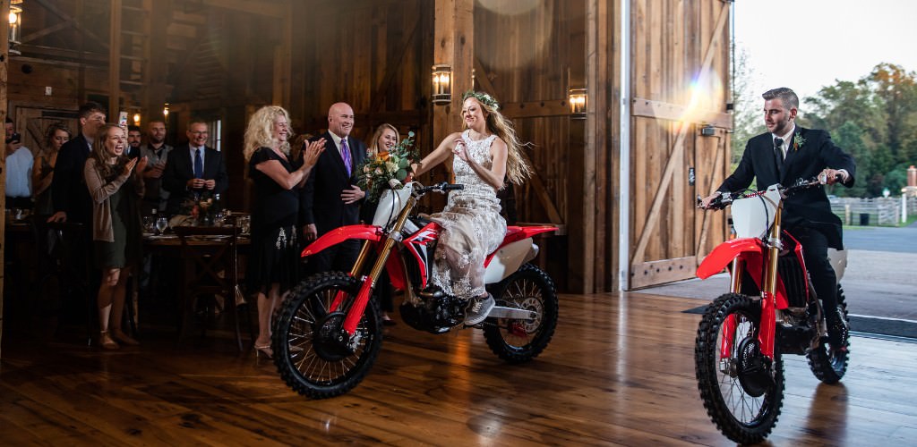 A bride and groom leaving the wedding reception on dirt bikes