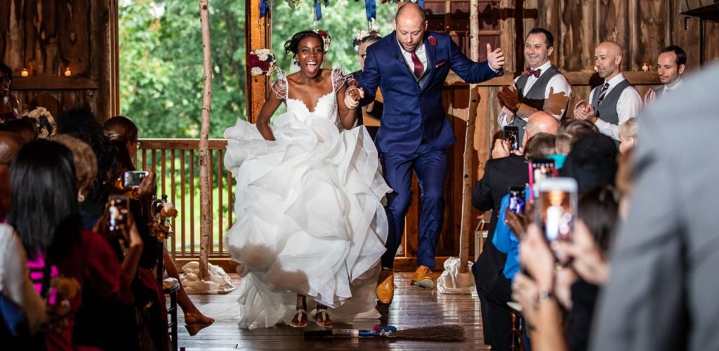 A bride and groom jumping the broom after their wedding ceremony