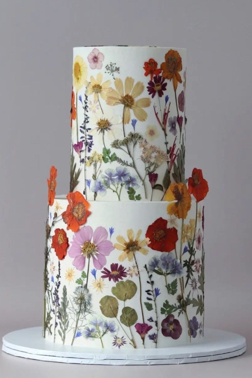 A two tier wedding cake with real pressed wildflowers