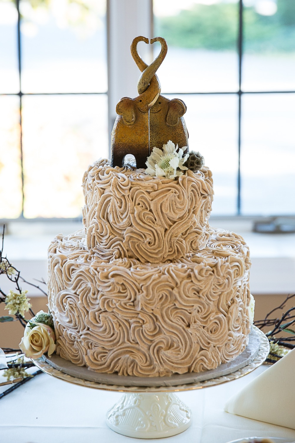 A unique two-tier wedding cake design with elephant cake topper