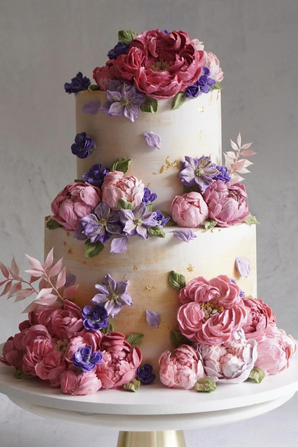 A pretty two-tier wedding cake with pink and purple flowers