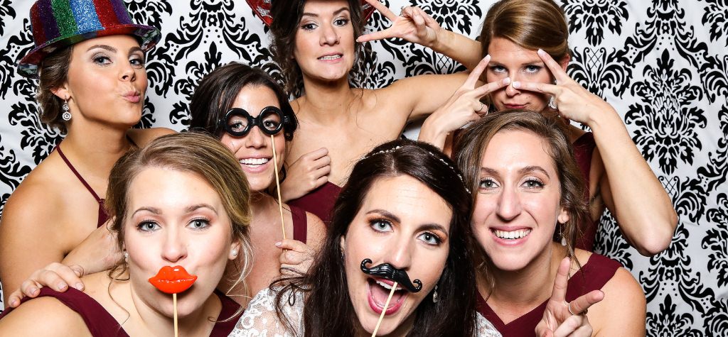 A bride and bridesmaids in the photo booth at a wedding